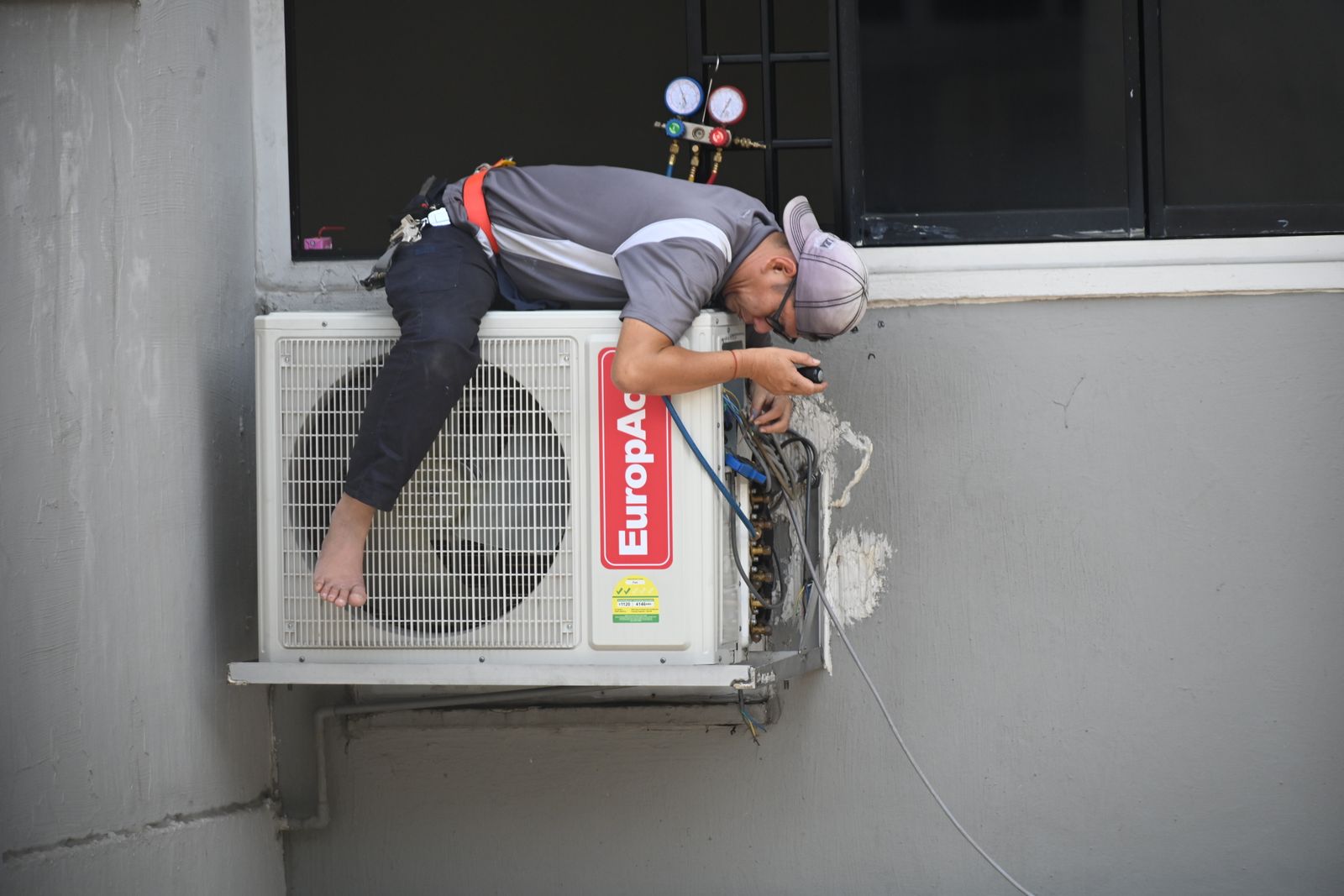 Technician working on an outdoor air-conditioning unit