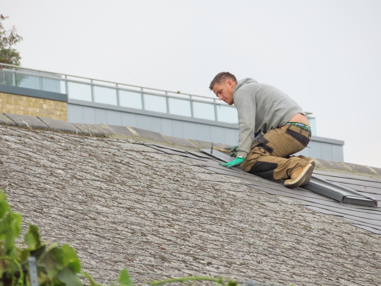 Worker installing shingles on a rooftop
